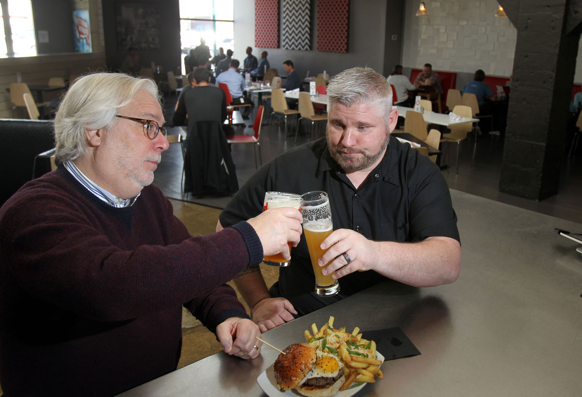 Grind Modern Burger co-owner Dusty enjoying beer with restaurant manager